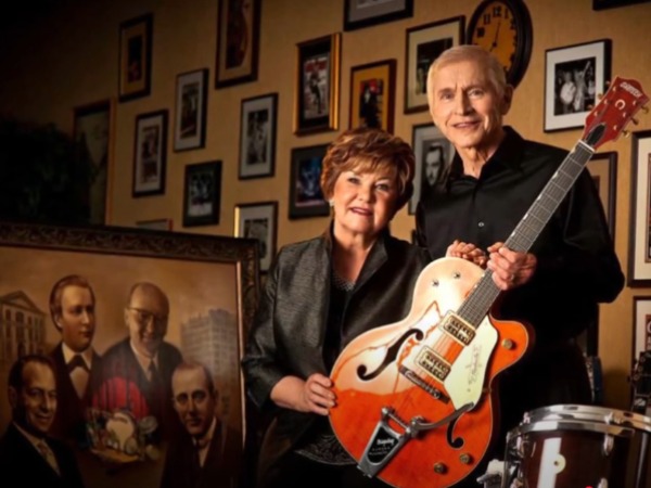 Fred and Dinah Gretsch with some of their instruments and a portrait of the four generations of Gretsch CEOs.