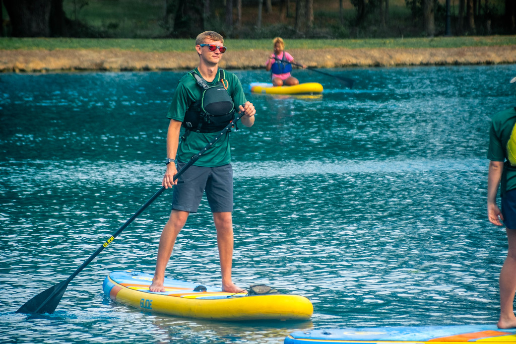 Georgia Southern students learn to paddle board on a beautiful lake through the Southern Adventures Center.