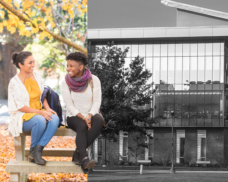 Two female Georgia Southern students sitting on a campus bench in the fall.