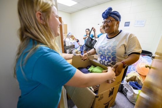 Student volunteers assist with loading and packing clothing and other essential items.