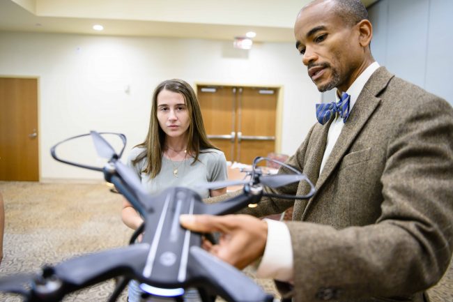 Wayne Johnson, Ph.D., examines a drone with mechanical engineering student Lydia Poole. Drones like this one will be used during the 2020 Engineering Design Challenge. 