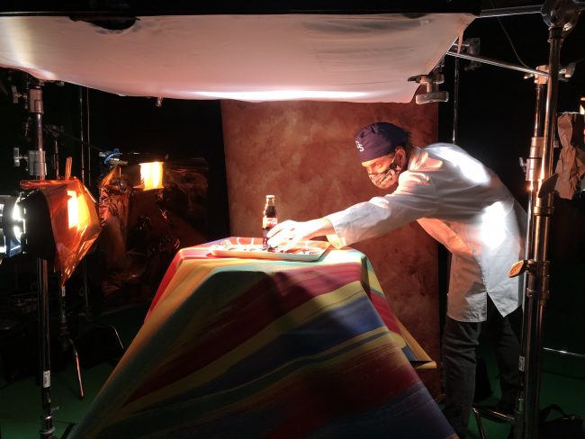 A student in professor Dean Cummings', Ph.D., studio applications class sets up a shot in the studio. The students have continued working in the studio safely throughout the COVID-19 pandemic.