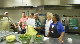 Reba Ellis of Atlanta, Georgia reads instructions as her team readies to prepare kale slaw, vegetarian “southern-style” collared greens and sesame carrot salads. School nutrition managers from across the state of Georgia gathered at Georgia Southern University to attend Culinary Institute II, a 32-hour, weeklong training session by the Georgia Department of Education’s School Nutrition Program. The training session includes instruction and hands-on experiences.