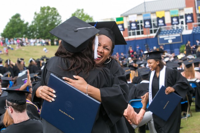 Two students embrace after receiving their degrees at the 2014 Georgia Southern University Spring Commencement ceremony. 