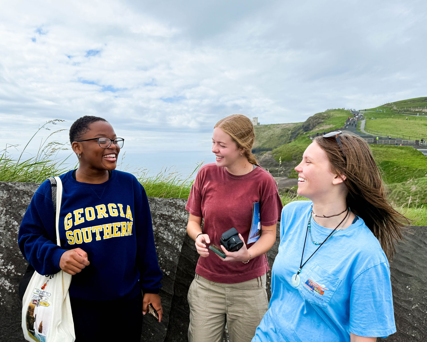 Three female Georgia Southern students smiling enjoying the view at the Cliffs of Moher in Ireland.