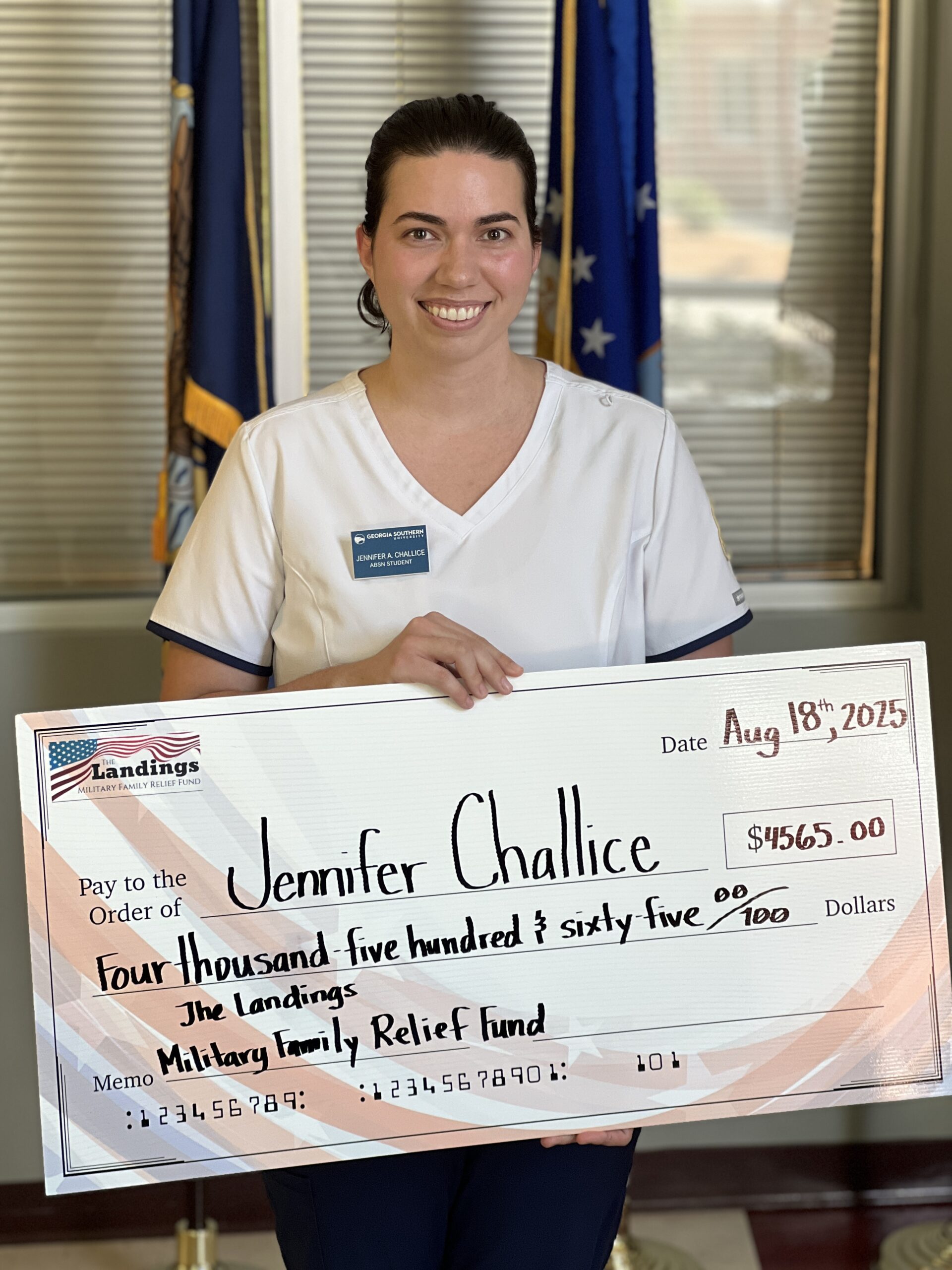 Jennifer Challice receives a novelty check representing her scholarship from the Landings Military Family Relief Fund.