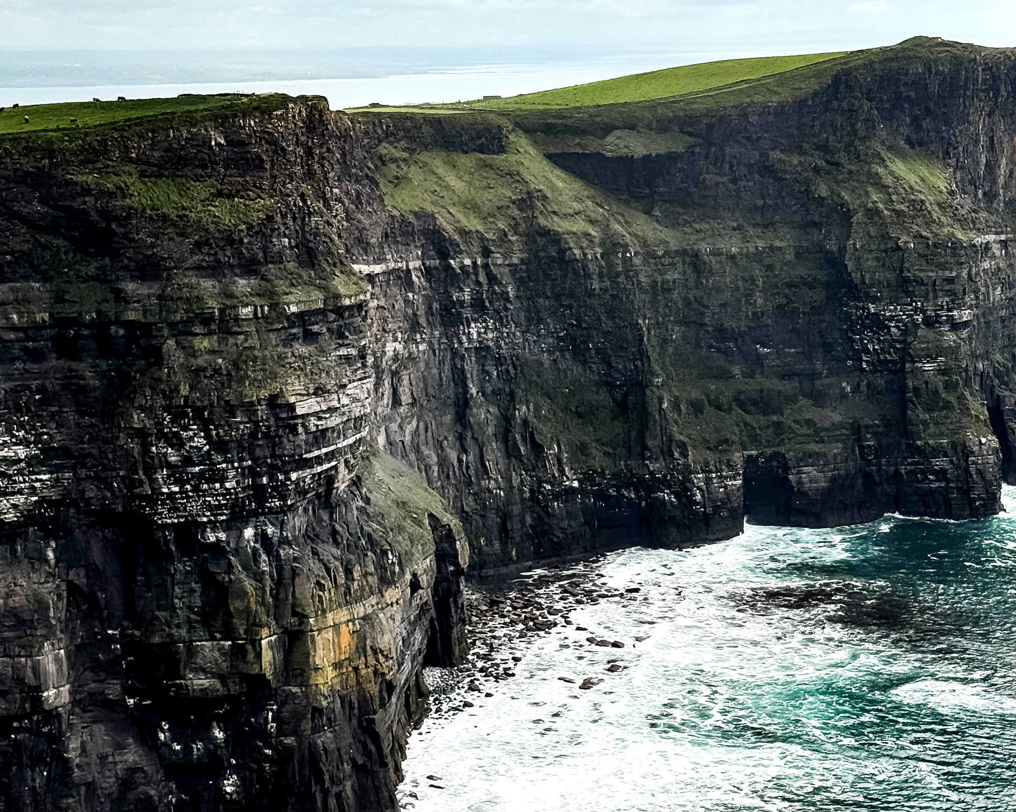 Beautiful photo of the Cliff of Moher and the ocean waves below them in Ireland.