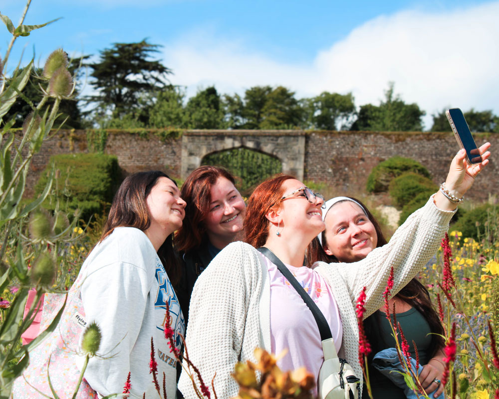 Georgia Southern students taking a selfie in a flower garden in Ireland.